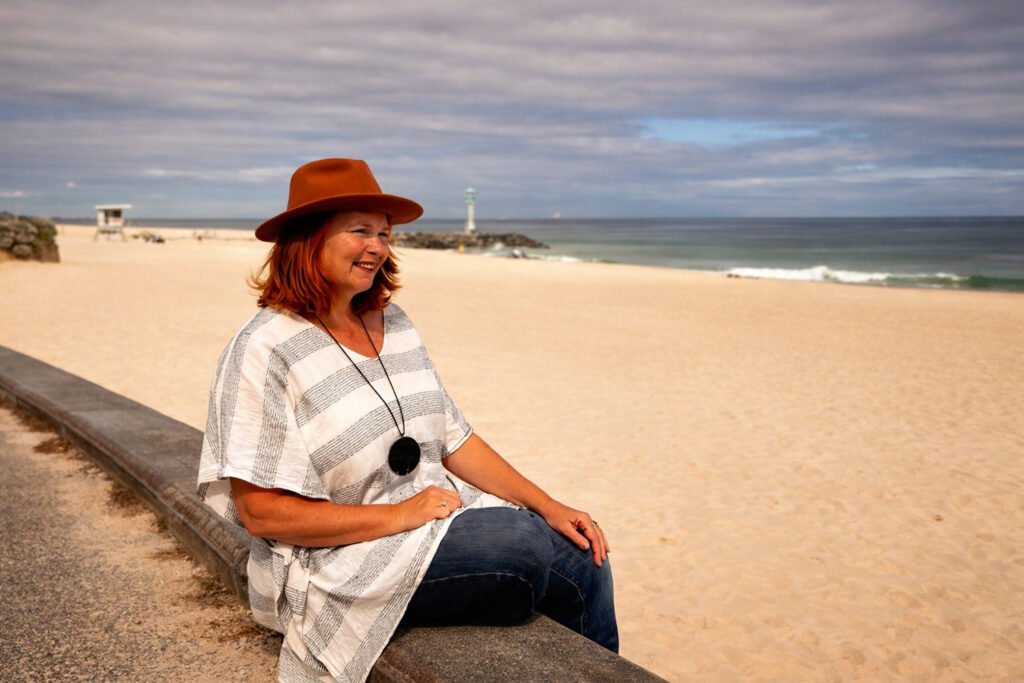 Marijke sitting at City Beach and overlooking the ocean admiring the beauty as is